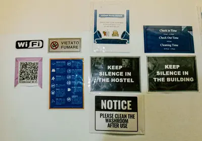 a wall with signs hanging on a wall at Minerva Rooms in Rome