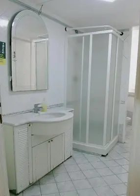 a white bathroom with a sink and a shower at Minerva Rooms in Rome