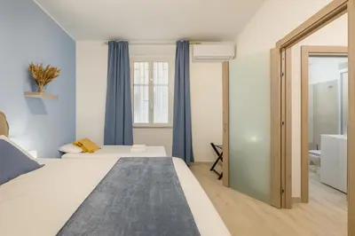 a bedroom with a large bed with blue curtains at RomeSweetHome Villa Borghese in Rome