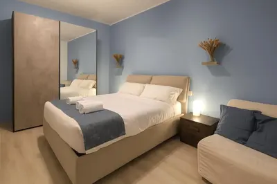a bedroom with a large bed and a mirror at RomeSweetHome Villa Borghese in Rome