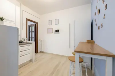 a kitchen with white cabinets and a wooden table at RomeSweetHome Villa Borghese in Rome