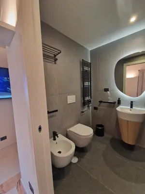 a bathroom with a white toilet and a sink at Corso Suite Style in Rome