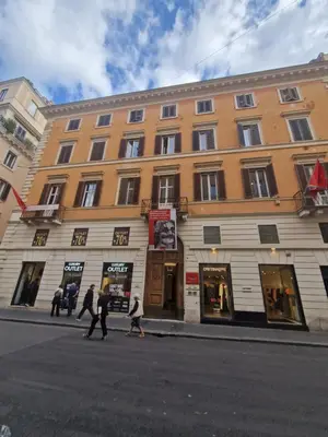 a group of people crossing a street in front of a building at Corso Suite Style in Rome