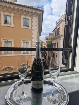a bottle of wine on a table with two glasses at Corso Suite Style in Rome