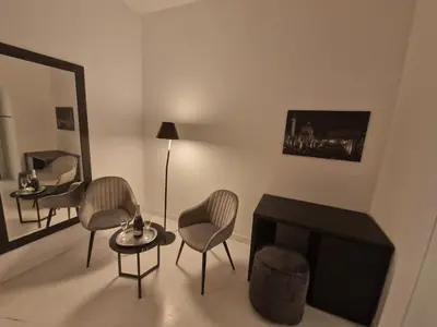 a living room with chairs and a table and a mirror at Corso Suite Style in Rome
