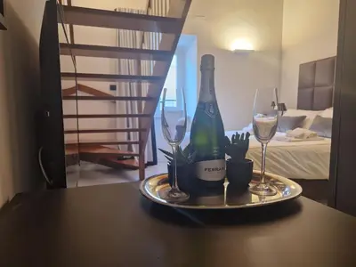 a plate with a bottle of wine and two glasses at Corso Suite Style in Rome