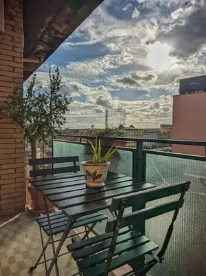 a wooden table with a potted plant on a balcony at SyrakaHost Intero appartamento in Rome