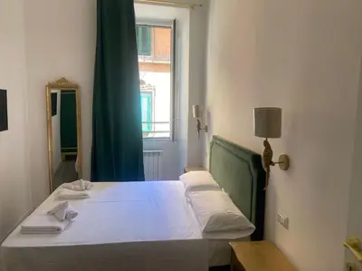 a bedroom with a bed with a green headboard and a mirror at New opening Sweet Apartament Trastevere in Rome