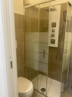 a bathroom with a toilet and a glass shower at New opening Sweet Apartament Trastevere in Rome