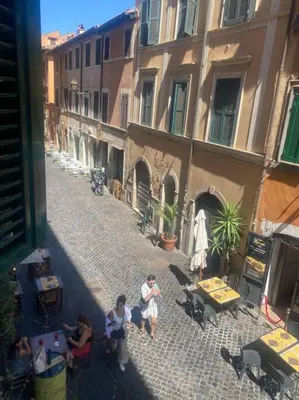 a group of people sitting on a street next to buildings at New opening Sweet Apartament Trastevere in Rome