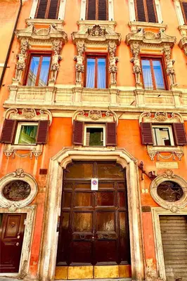 an orange building with two doors and windows at Palazzo Centini Toni - Rome with style in Rome