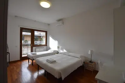 a bedroom with white walls and a bed with white sheets at Vassallo B&B in Rome