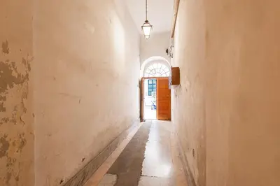 an empty hallway with an orange door and a window at Maison della Luce in Rome