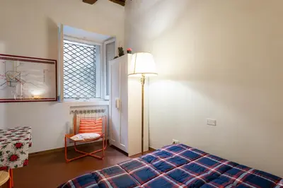 a bedroom with a bed and a lamp and a chair at Maison della Luce in Rome