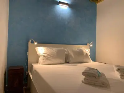 a bed with white pillows and a blue wall at Navona Rhome in Rome