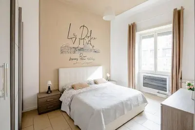 a white bedroom with a bed and a tv at Dolcevita San Lorenzo luxury in Rome