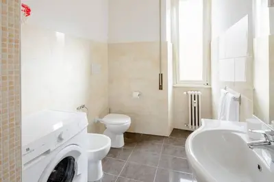 a white bathroom with a toilet and a sink at Dolcevita San Lorenzo luxury in Rome