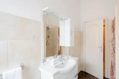 a white bathroom with a sink and a mirror at Dolcevita San Lorenzo luxury in Rome