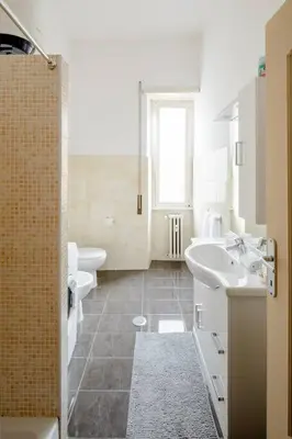 a white bathroom with two sinks and a shower at Dolcevita San Lorenzo luxury in Rome