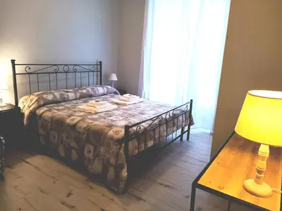 a bedroom with a bed and a table and a lamp at Casa Paolina a Metro San Paolo in Rome