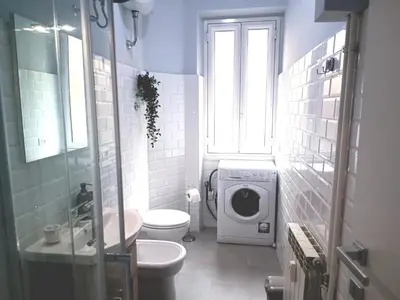 a bathroom with a toilet and a washing machine at Casa Paolina a Metro San Paolo in Rome