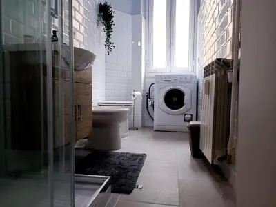 a bathroom with a toilet and a washing machine at Casa Paolina a Metro San Paolo in Rome
