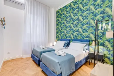 a bedroom with two beds and a mural of trees at The Heart of Rome Luxury House in Rome