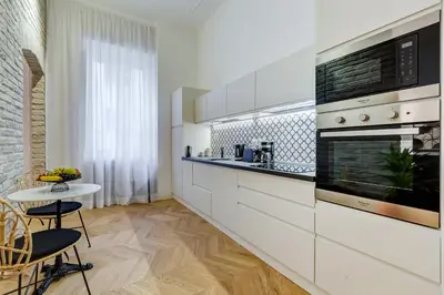 a kitchen with white cabinets and a stove top oven at The Heart of Rome Luxury House in Rome