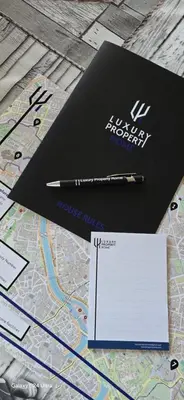a black notebook and a pen on a map at The Heart of Rome Luxury House in Rome