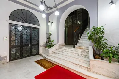 a hallway with a red carpet and stairs with a red rug at The Heart of Rome Luxury House in Rome