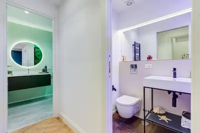 a bathroom with a sink and a toilet and a mirror at The Heart of Rome Luxury House in Rome