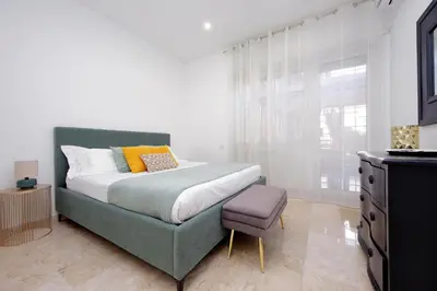 a bedroom with a bed and a chair and a dresser at Lovely apartment with terrace near the Vatican in Rome