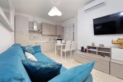 a living room with a blue couch and a tv at Lovely apartment with terrace near the Vatican in Rome
