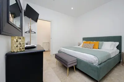 a bedroom with a large bed and a chair at Lovely apartment with terrace near the Vatican in Rome