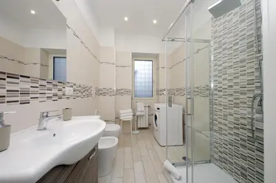 a white bathroom with a sink and a shower at Lovely apartment with terrace near the Vatican in Rome