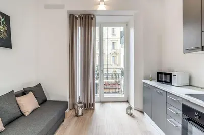 a living room with a couch and a kitchen at Vatican Portrait Suites in Rome