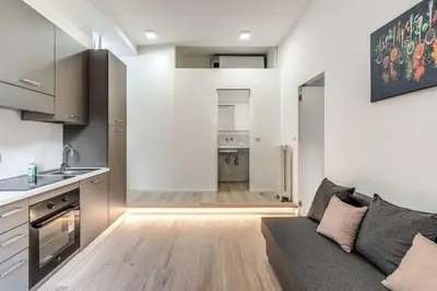 a living room with a couch and a kitchen at Vatican Portrait Suites in Rome