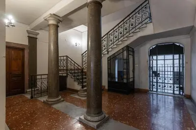 an empty room with columns and stairs in a house at Vatican Portrait Suites in Rome