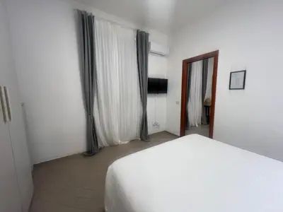 a bedroom with a white bed and a window at Casa Gemelli in Rome