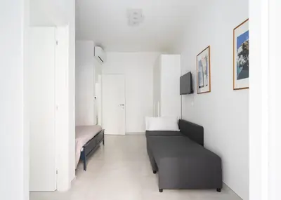 a white room with two beds and a couch at @uRhOME - Luxury Accommodation in Rome