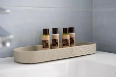 a shelf with four lip gloss bottles on it at @uRhOME - Luxury Accommodation in Rome