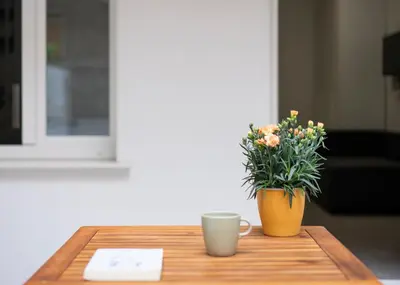 a table with two cups and a vase with flowers at @uRhOME - Luxury Accommodation in Rome