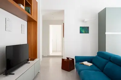 a living room with a blue couch and a tv at @uRhOME - Luxury Accommodation in Rome