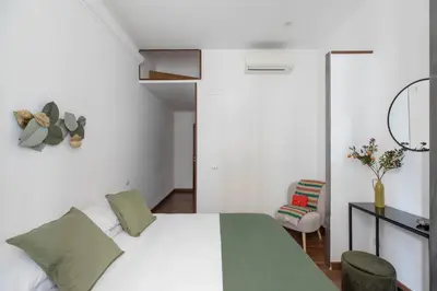 a bedroom with a white bed and a chair at iFlat Colosseum Charming Flat in Rome