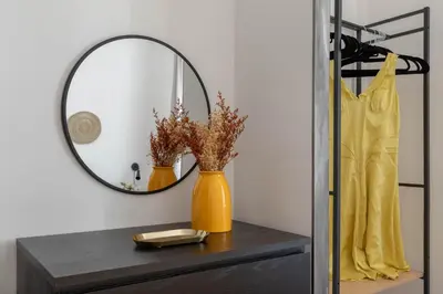 a mirror on top of a dresser with a vase at iFlat Colosseum Charming Flat in Rome