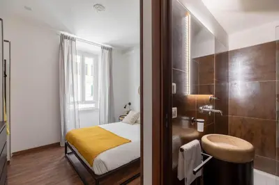 a small bedroom with a bed and a shower at iFlat Colosseum Charming Flat in Rome
