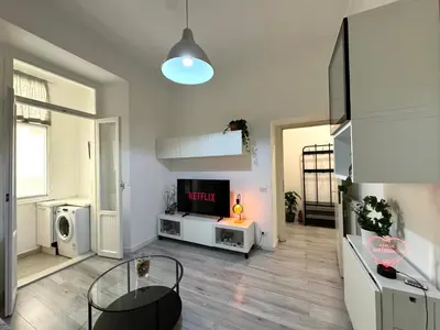 a living room with a television and a table at AmoR San Lorenzo in Rome