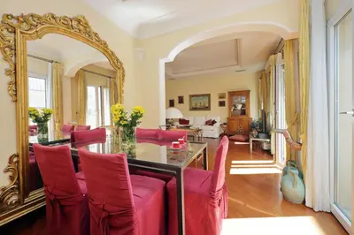 a dining room with a large mirror and red chairs at 3V Luxury Apartment by Hili in Rome