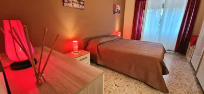 a bedroom with two beds and a table with a candle at Holiday home Telese Roma in Rome