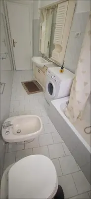 a white bathroom with a toilet and a sink at Holiday home Telese Roma in Rome